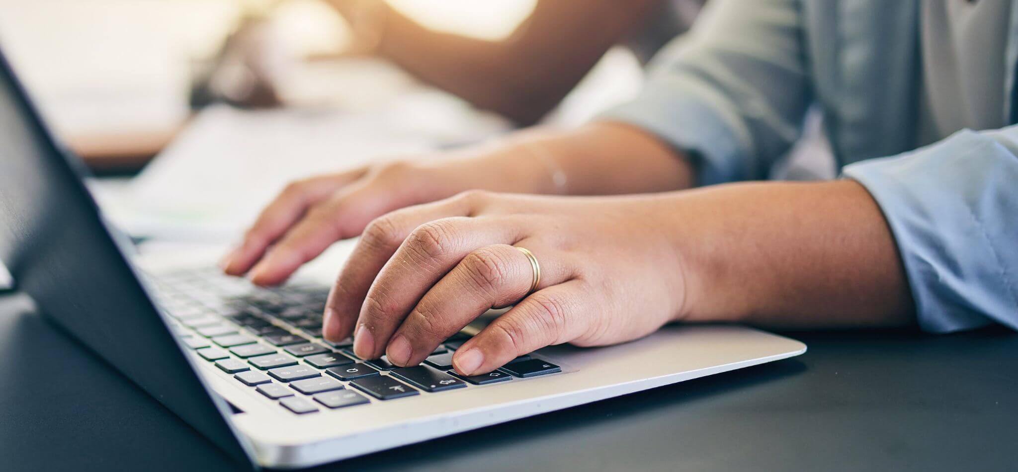 hands typing on keyboard to find major donors for nonprofits on a budget