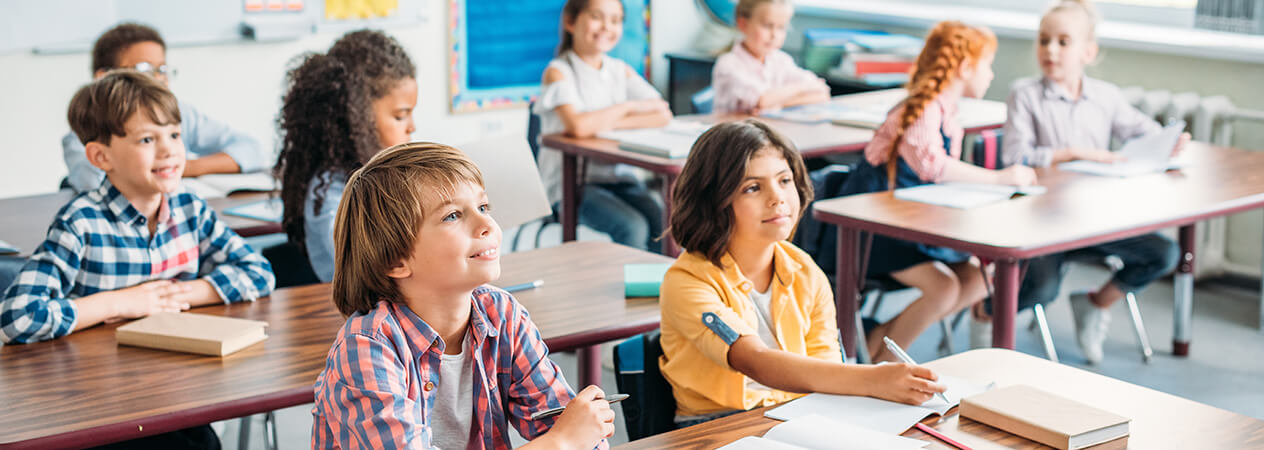 Children sitting in their desks in a classroom.